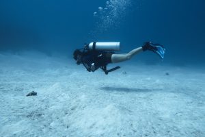 Scuba diver cruising through open reef zone