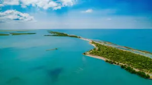 An aerial view of Cayo Centro island in Banco Chinchorro biosphere reserve surrounded by clear turquoise water.